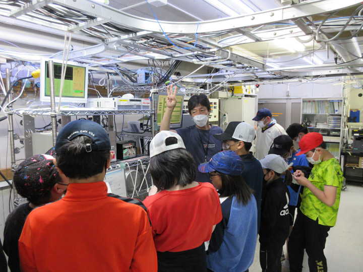 写真2 ステーション内に設置されている観測機器について説明を受ける子どもたち