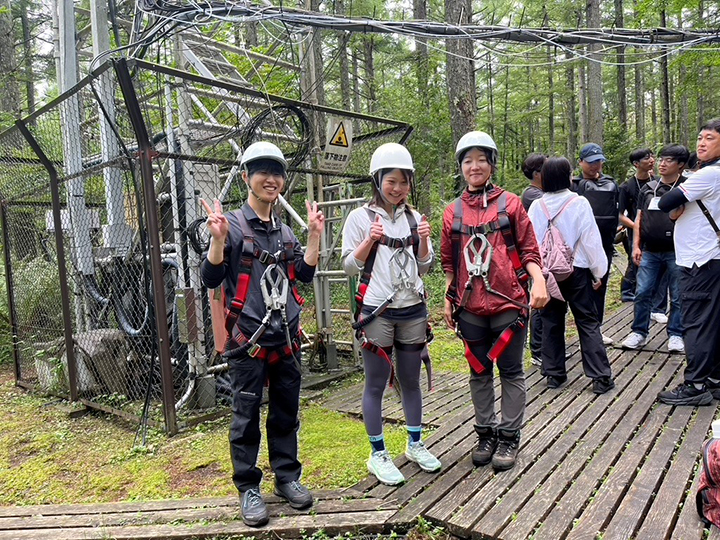 写真2 現地共同視察で富士北麓フラックス観測サイトのフラックスタワーに登る若手研究者。フルハーネス型の墜落防止器具の装着に手間がかかりましたが、貴重な体験となりました