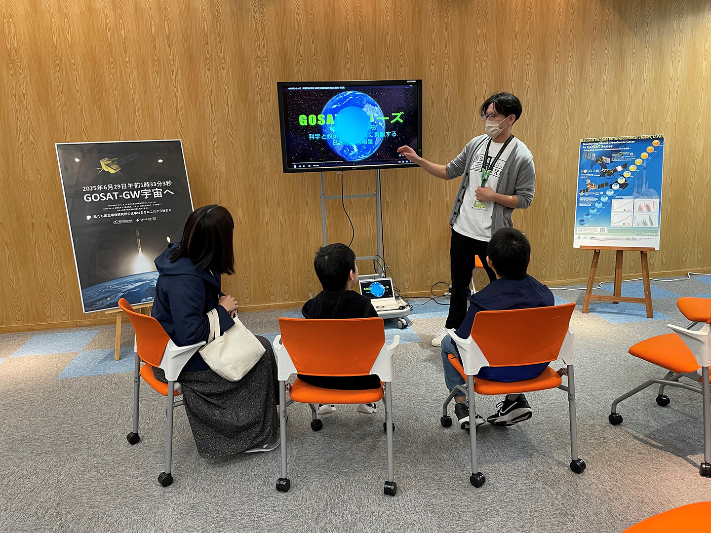 藤縄主任研究員（右）がGOSATシリーズ（※）について説明している様子。